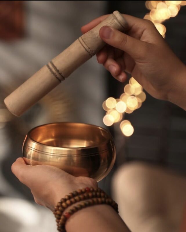 Himalayan singing bowl resting on a wooden altar, warm natural light, minimalist setting