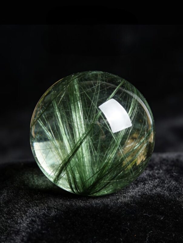 Detail shot of Silver and Green Rutilated Quartz beads showing the fine silvery-gray and soft green needle inclusions respectively, demonstrating the subtler color range of these rarer varieties.