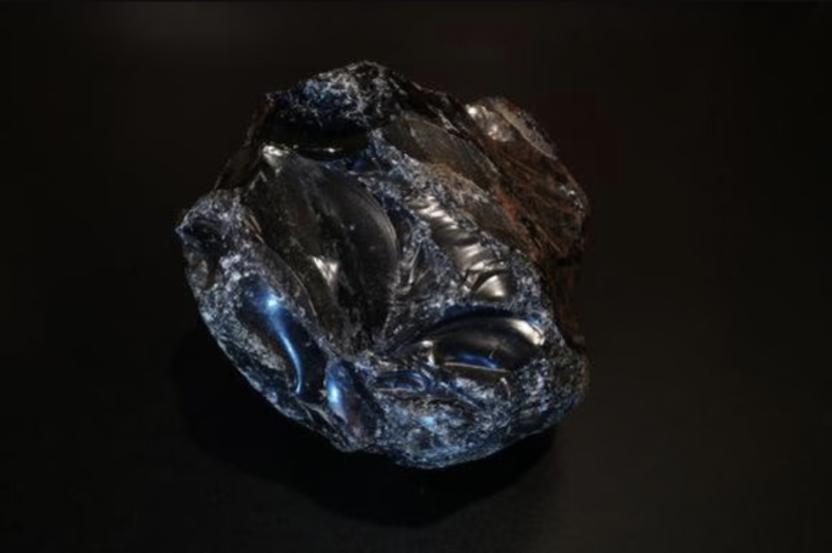 Raw black obsidian volcanic glass specimen showing natural conchoidal fracture and deep black luster