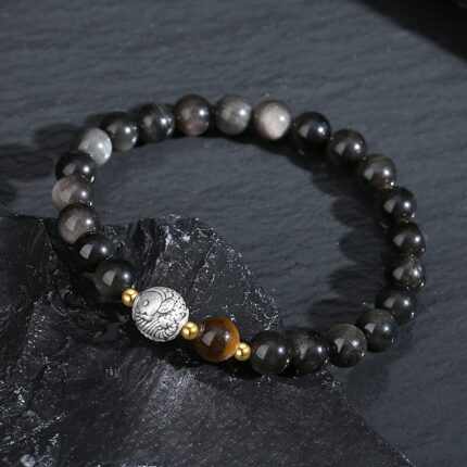 Black Obsidian volcanic glass bead detail, deep jet black polished surface, natural grey veining, 8mm round bead