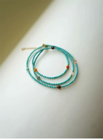 Sky-blue Turquoise bead detail, polished surface, natural colour variation between beads, gold spacer bead, polished round Turquoise beads