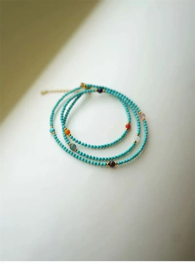 Sky-blue Turquoise bead detail, polished surface, natural colour variation between beads, gold spacer bead, polished round Turquoise beads