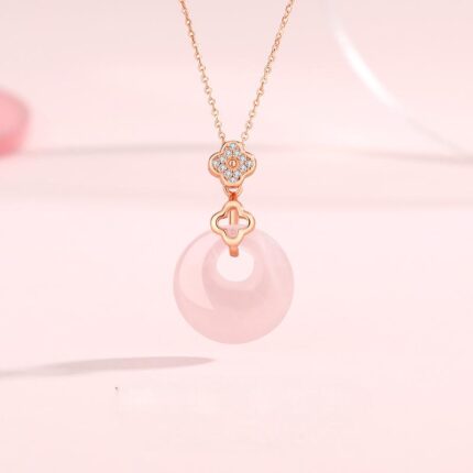 Close-up of natural rose quartz peace buckle showing translucent pink texture and silver four-leaf clover bezel