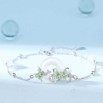Flat-lay on white or linen background showing the full chain with peace circle pendant, three butterflies, and pearl accents clearly visible. Natural light preferred.