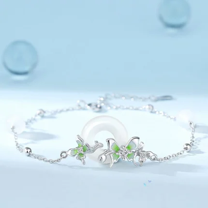Flat-lay on white or linen background showing the full chain with peace circle pendant, three butterflies, and pearl accents clearly visible. Natural light preferred.