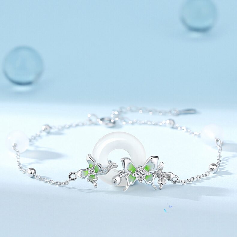 Flat-lay on white or linen background showing the full chain with peace circle pendant, three butterflies, and pearl accents clearly visible. Natural light preferred.