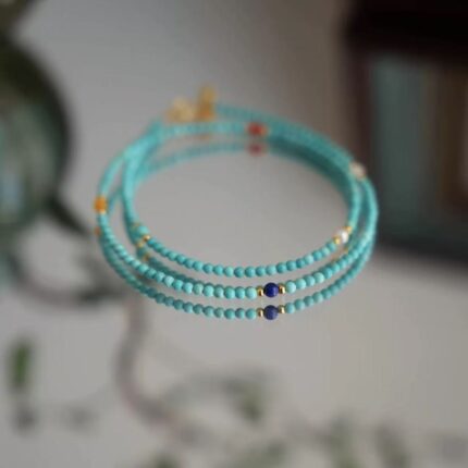 Cloud Ease Turquoise necklace set, three Turquoise necklaces in 40cm 50cm 60cm lengths, sky-blue polished beads with gold spacers, complete set flat lay, natural lighting