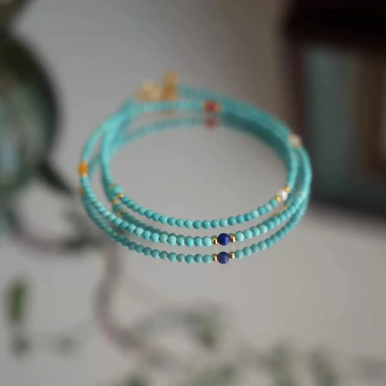 Cloud Ease Turquoise necklace set, three Turquoise necklaces in 40cm 50cm 60cm lengths, sky-blue polished beads with gold spacers, complete set flat lay, natural lighting