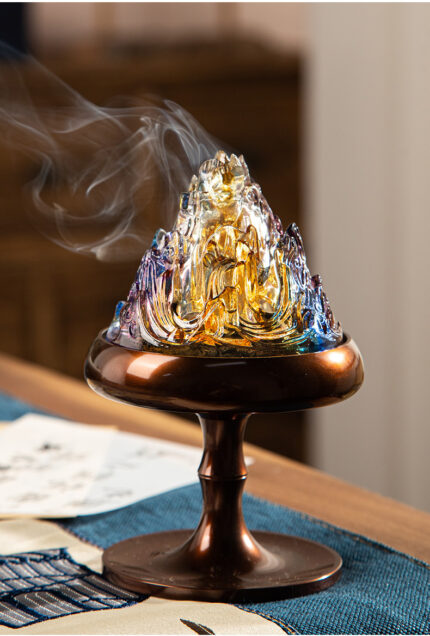 Chinese glazed Boshan incense burner, translucent mountain peak琉璃cap on polished bronze stand, warm candlelight glowing through glaze, natural surface, warm natural lighting