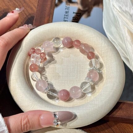 Strawberry quartz bead detail, translucent quartz with red-brown strawberry seed inclusions, characteristic natural iron oxide and mica inclusions, 10mm round polished bead