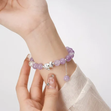 Amethyst and silver Pixiu bracelet worn on the wrist — spiritual prosperity jewelry in daily context.