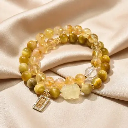 Double-wrap yellow tiger's eye and rutilated quartz bracelet on wrist, warm golden tones, casual elegant styling