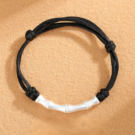 A minimalist adjustable black braided cord bracelet with an S925 silver bamboo segment charm, brushed silver finish, on a white background.