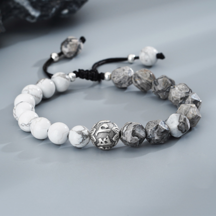 Detail of the S925 silver Six Syllable Mantra bead with intricate carved auspicious motifs on the Om bracelet.