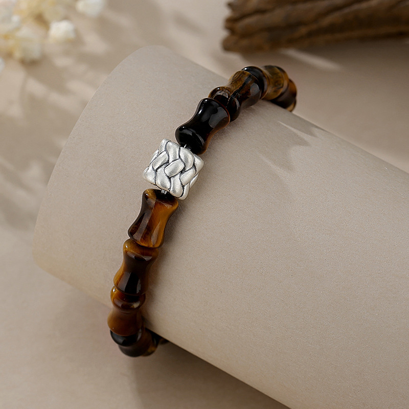 Close-up detail of bamboo-joint Tiger Eye beads showing chatoyant golden-brown luster, S925 silver rope knot ornament, antique finish silver detail