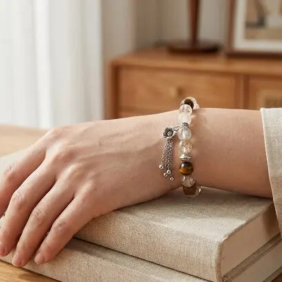 Black Gold Super Seven bracelet on wrist next to a cup of tea, soft natural morning light, calm workspace atmosphere