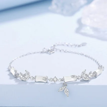 Flat-lay on white or neutral background showing the full chain with four bamboo joint beads, CZ accents, and mermaid tail charm clearly visible. Natural light to show the frosted agate surface.
