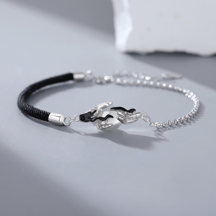 A minimalist men's bracelet with a braided black cord on one side and a fine silver chain on the other, centered by a sculpted crane charm cradling a pale white agate drop stone.